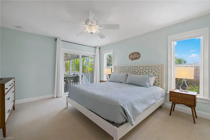 Bedroom featuring access to outside, light carpet, and ceiling fan