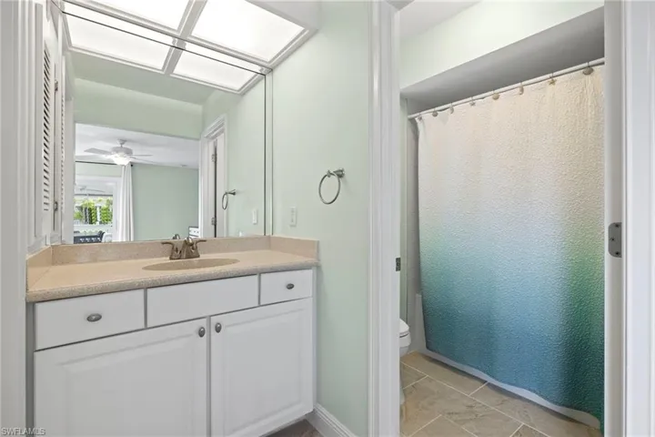 Bathroom featuring vanity, toilet, and ceiling fan