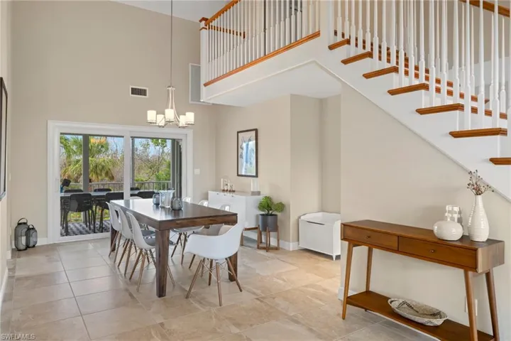Dining space with an inviting chandelier and a high ceiling