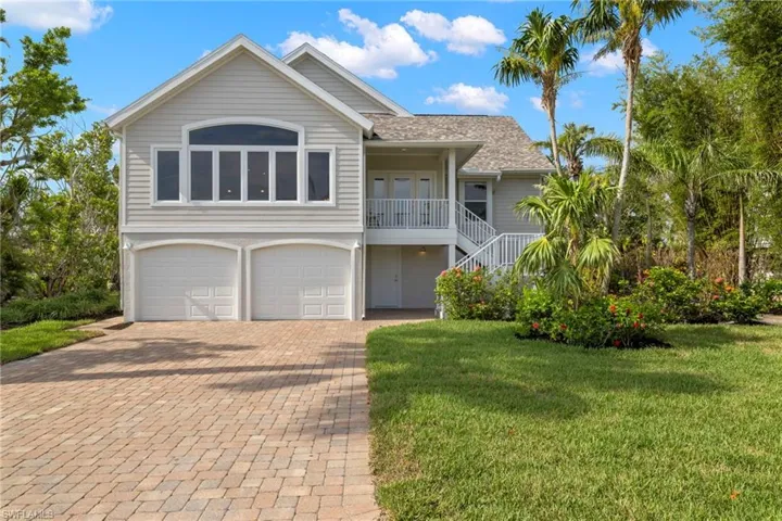 View of front facade featuring a front yard and a garage