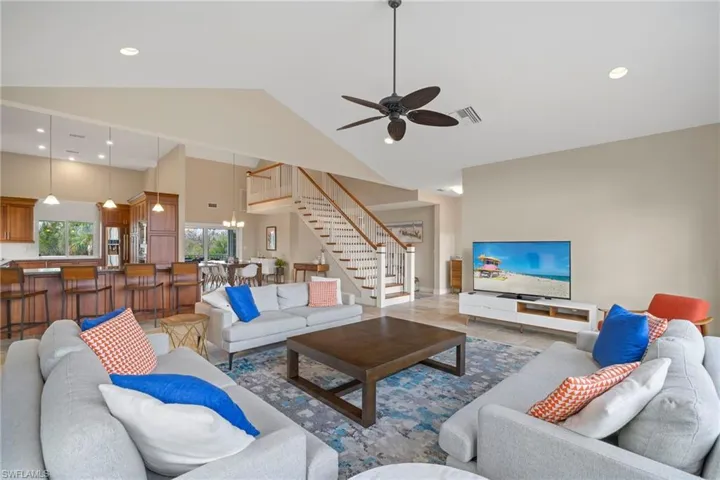 Living room featuring hardwood / wood-style floors, ceiling fan, and high vaulted ceiling