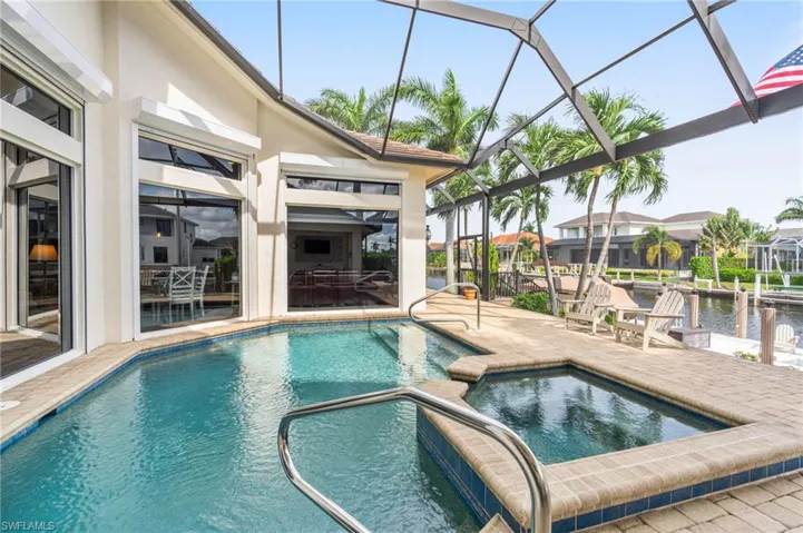 View of swimming pool featuring a lanai, a patio, and an in ground hot tub