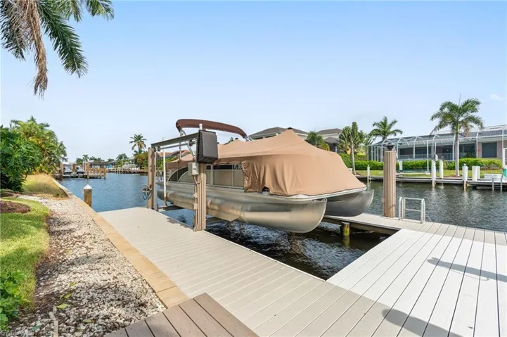 View of dock featuring a water view and glass enclosure