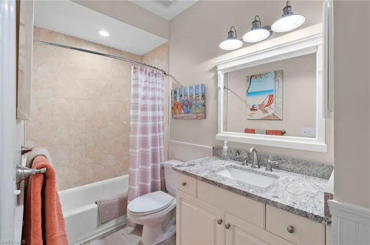 Full bathroom with shower / tub combo, vanity, and toilet