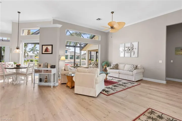 Living room featuring light hardwood / wood-style floors, ceiling fan, and a healthy amount of sunlight