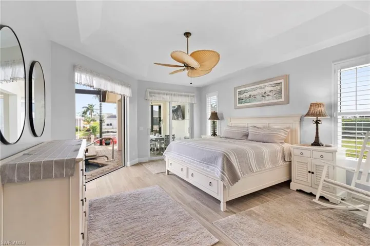 Bedroom with multiple windows, access to outside, light hardwood / wood-style floors, and ceiling fan