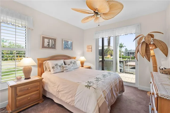 Bedroom featuring multiple windows, access to exterior, and ceiling fan