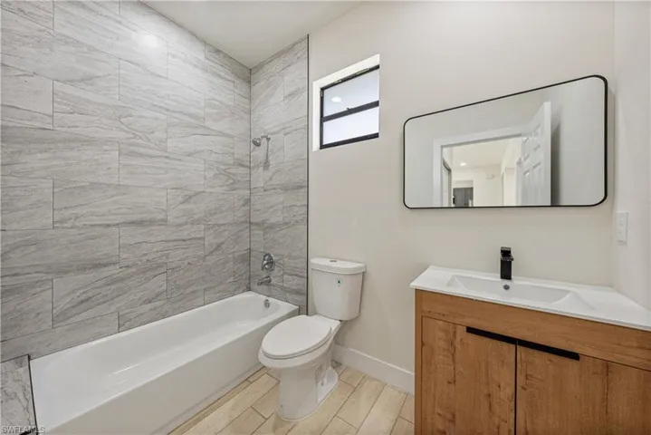 Full bathroom with vanity,  shower combination, and wood finish floors