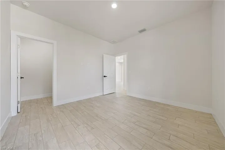 Unfurnished room featuring a smoke detector and light wood finished floors