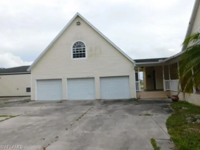 View of front of home with a garage, covered porch, and concrete driveway