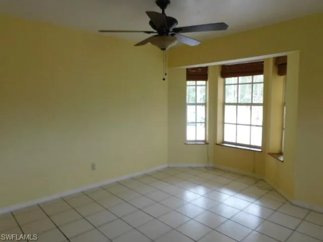 Unfurnished room featuring light tile patterned floors and ceiling fan