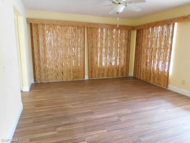 Spare room with baseboards and wood finished floors