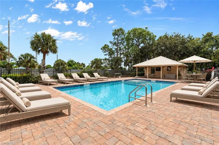 Rectangular swimming pool with integrated steps, surrounded by brick paver decking. AI staging of pool furniture.