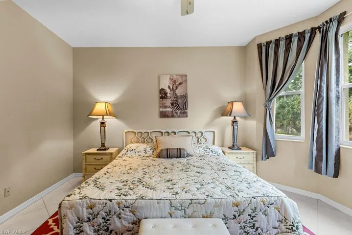 Light-toned walls, ceiling fan, and bay windows