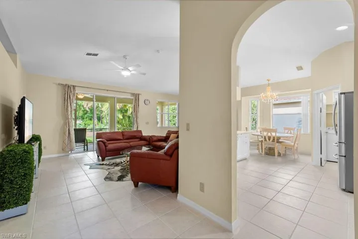 Tiled flooring throughout, an arched entryway, and sliding glass doors to outdoor living space