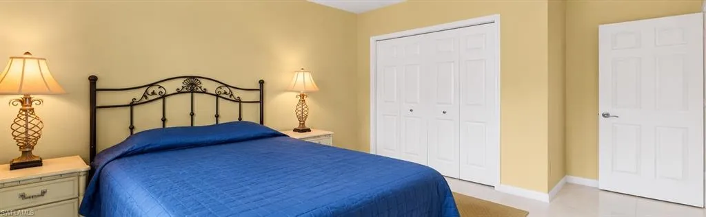Room featuring a four-panel closet with white bi-fold doors, a solid-core six-panel interior door, and neutral-toned wall paint