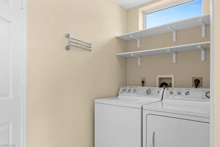 Built-in shelving for storage, a window providing natural illumination, and a wall-mounted drying rack