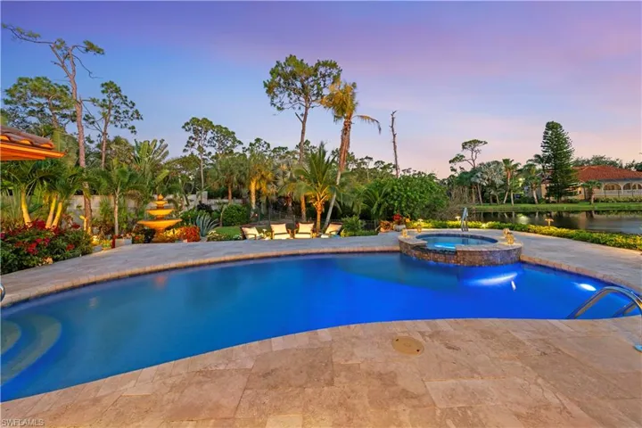View of heated pool and spa with lake view