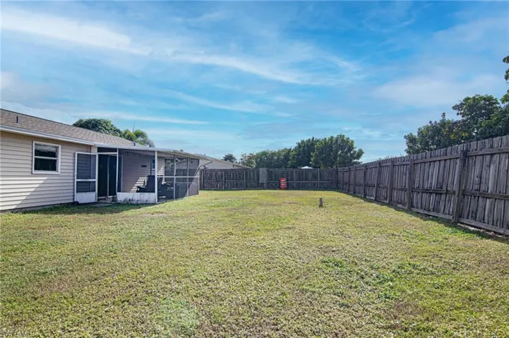 Fenced backyard with a sunroom