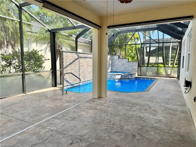 Screened patio featuring a stamped concrete surface and an integrated pool