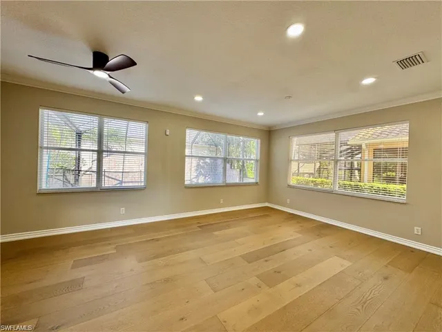 Spacious room featuring wood-finish flooring, recessed lighting, and a modern ceiling fan