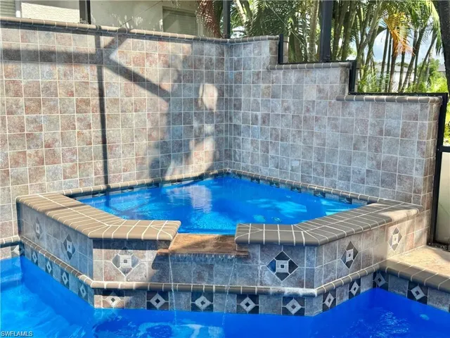 Tiled spa area with an integrated spillover feature into the main pool