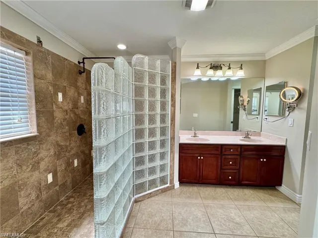Spacious bathroom featuring a glass block shower enclosure, tiled walls, and a window with blinds