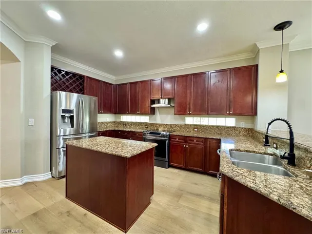 Kitchen featuring wood-finish flooring, dark wood cabinetry, and granite countertops