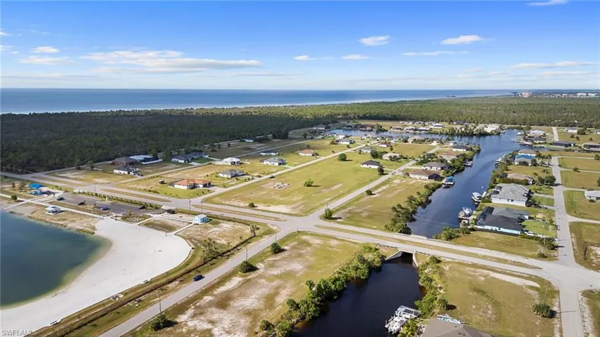 Aerial view of property and surrounding area with a nearby body of water and nearby suburban area