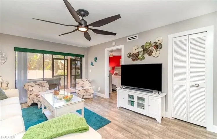 Living area with light wood-type flooring and a ceiling fan