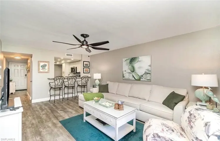 Living area with light wood finished floors and ceiling fan