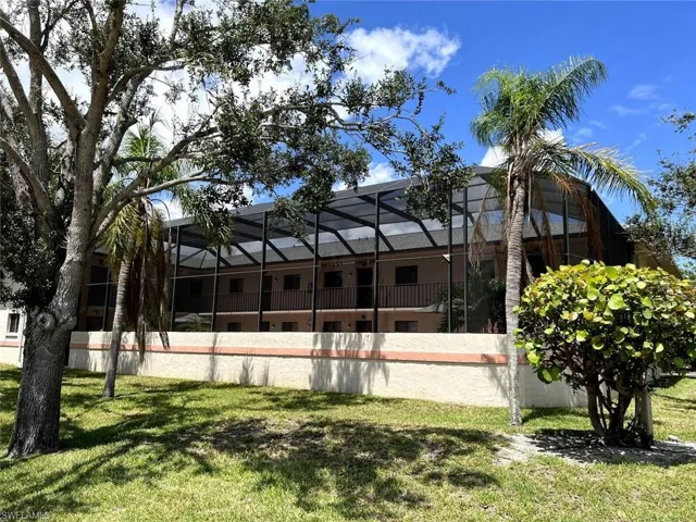 Back of property with a yard, glass enclosure, and a sunroom