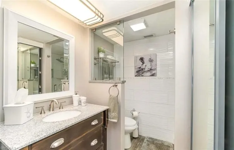 Bathroom with vanity, a stall shower, and dark wood-type flooring