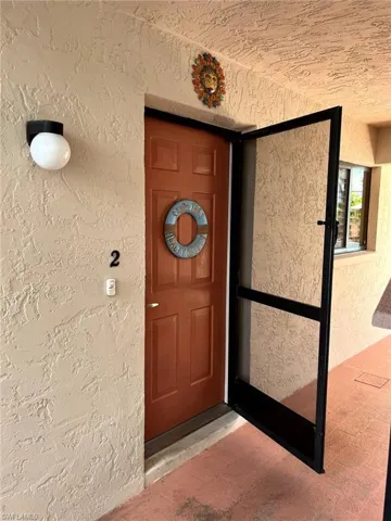 Doorway to property featuring stucco siding