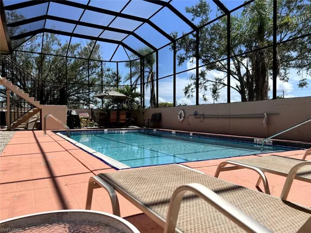 Community pool featuring a lanai, a patio area, and stairs