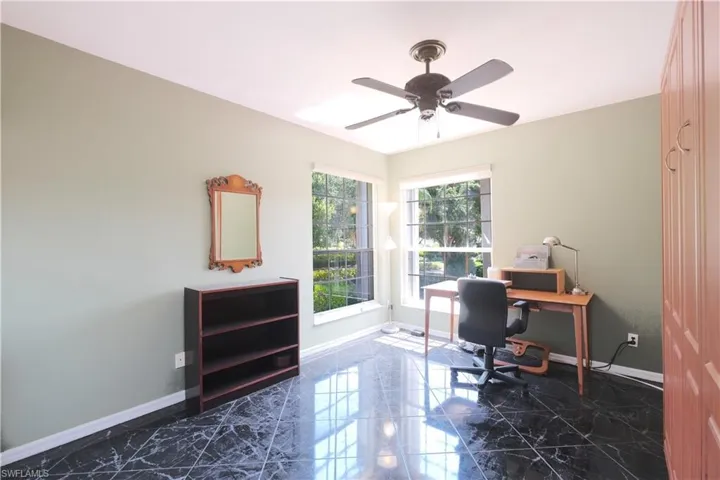 Office space featuring dark tile flooring and ceiling fan