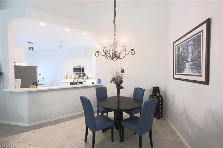 Dining room featuring light tile floors and ceiling fan with notable chandelier