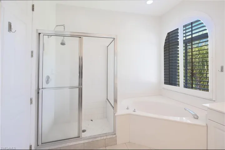 Bathroom featuring independent shower and bath, vanity, and tile floors