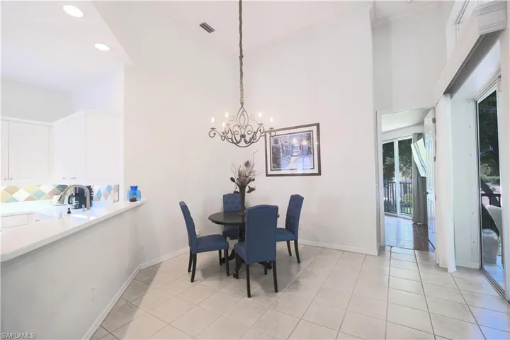Tiled dining space with a high ceiling and a chandelier