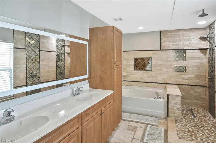 Owner's bath features dual sinks, LED mirror, and lots of cabinet space.