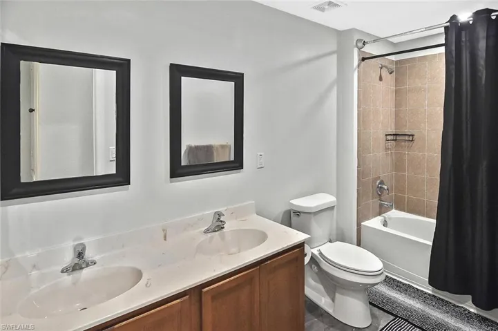Guest bath with dual sinks and tub/shower combo.