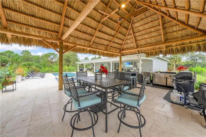 View of patio / terrace featuring outdoor dining space, a grill, and an outdoor pool