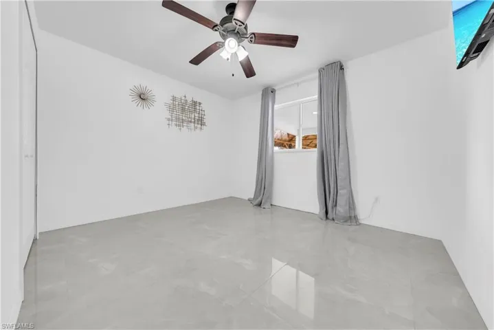 Spare room featuring ceiling fan and baseboards