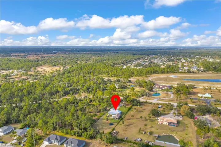 Aerial overview of property's location with nearby suburban area and a forest