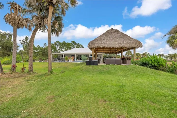 View of green lawn with a patio, an outdoor living space, and a gazebo