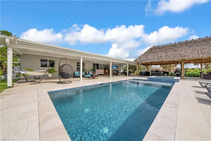 View of swimming pool with an outdoor hangout area, a patio area, and a pool with connected hot tub