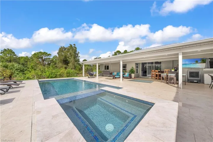 View of swimming pool featuring a patio area, outdoor lounge area, and a pool with connected hot tub