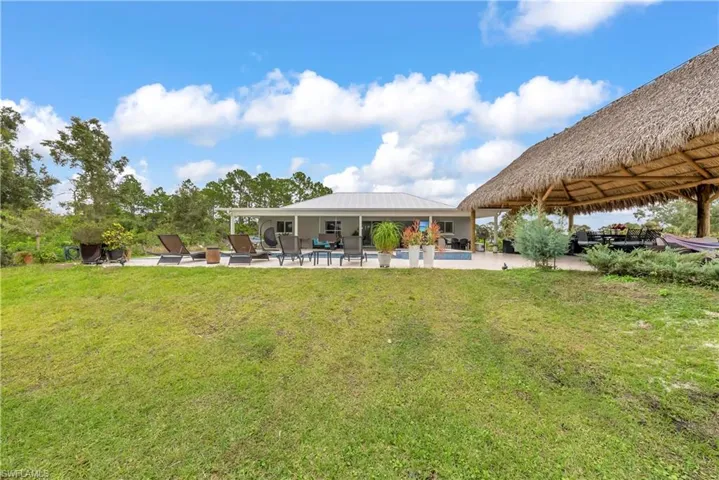 Back of property featuring a yard, a patio area, and a metal roof