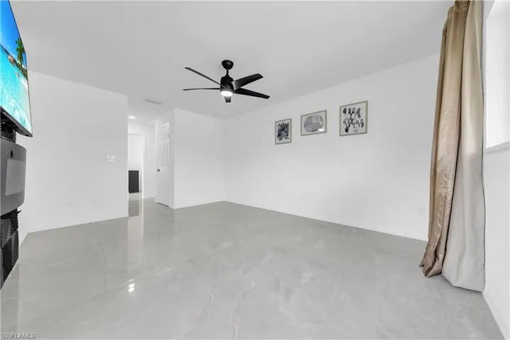 Empty room with light marble finish flooring and ceiling fan