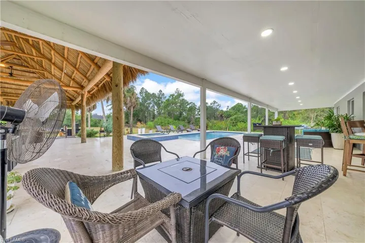 View of patio featuring outdoor dining space and a pool with connected hot tub